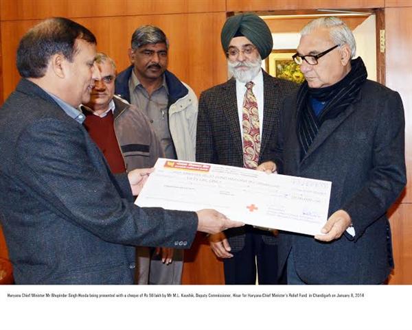 Haryana CM Bhupinder Singh Hooda being presented with a cheque of Rs 50 lakh by Mr M.L. Kaushik, Deputy Commissioner, Hisar for Haryana Chief Minister’s Relief Fund  in Chandigarh 
