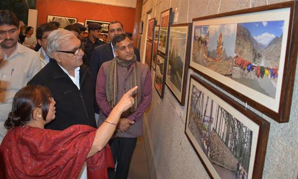 Haryana CM Bhupinder Singh Hooda keenly watching the photographs at the Exhibition – Mates and Moments, going on in the Open Palm Court Gallery at the India Habitat Center, New Delhi