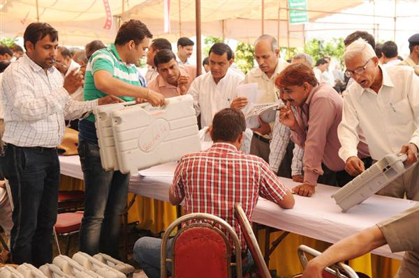 Polling officials at a distribution centre of the Electronic Voting Machines (EVM&#39;s) and other necessary inputs required for the General Elections-2014, in Sonipat Lok Sabha constituency, Haryana