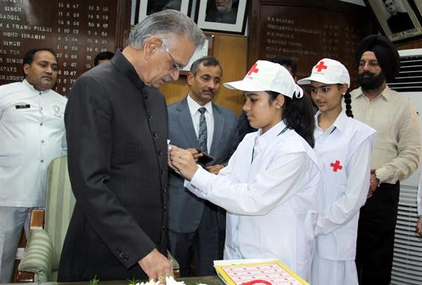 Alisha Kukreja students of Sacred Heart Senior Secondary School Moga, pinning a Flag on the Punjab Governor and Administrator, Union Territory, Chandigarh, Mr. Shivraj V. Patil on the occasion of Red Cross Flag Day